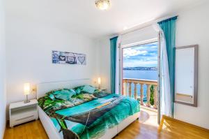 a bedroom with a bed and a large window at Balkon mit Meerblick direkt am Strand in Jadranovo