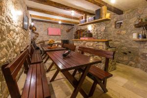 a row of wooden tables in a room with stone walls at Balkon mit Meerblick direkt am Strand in Jadranovo
