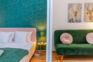 1 dormitorio con 1 cama y 1 sofá verde en RothApartments'ALICE, en Budapest