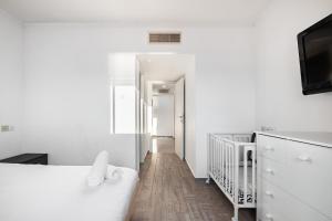 a white bedroom with a white bed and a hallway at LuxuryApt/BestView/PerfectForFamilies/FreeParking in Eilat