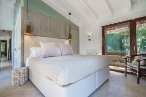 バルデモーサにあるCan Ganesha Villaのベッドルーム(大きな白いベッド1台、バルコニー付)