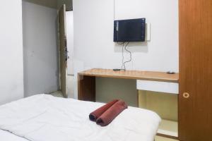 Una cama con escritorio y una toalla. en Tebet Glory House Mitra RedDoorz, en Yakarta