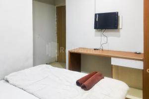 uma toalha deitada numa cama num quarto em Tebet Glory House Mitra RedDoorz em Jakarta
