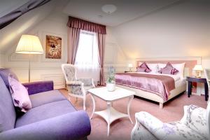 a bedroom with a bed and two chairs and a table at Boutique Hotel Hviezdoslav in Kežmarok