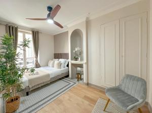 um quarto com uma cama, uma cadeira e uma janela em Champs Elysées area - Deluxe Family Apartments em Paris