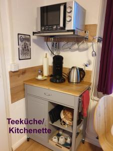 a small kitchen with a counter with a microwave at Apartment Heideland in Buchholz in der Nordheide