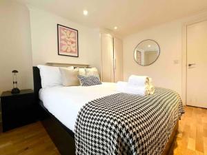 a bedroom with a large bed with a black and white blanket at Hyde Park- 1 Bed in London