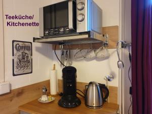a kitchen counter with a microwave on a shelf at Apartment Heideland in Buchholz in der Nordheide