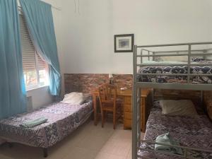 a bedroom with two bunk beds and a desk with a chair at Hostal El Alba in Brunete