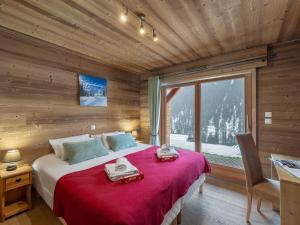 a bedroom with a large bed with a red blanket at Etringa 8 - Chalet Mitoyen - BO Immobilier- remises sur les forfaits de skis Châtel ou Portes du soleil in Châtel