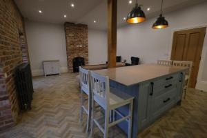 a kitchen with a counter and chairs in a room at Red Lion Apartments in Spalding
