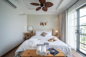 a bedroom with a bed and a ceiling fan at La Mer Villa in Bình Tú