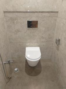 a bathroom with a white toilet in a stall at Hotel Amar Palace Ahmednagar in Ahmadnagar