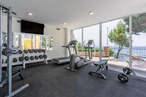een fitnessruimte met cardio-apparatuur en een groot raam bij Luxusapartment mit Pool, Sauna, direkt am Meer in Novi Vinodolski