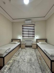 2 Betten in einem Zimmer mit Fenster in der Unterkunft HOTEL ARAL in Nukus