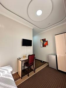 ein Hotelzimmer mit einem Schreibtisch, einem Bett und einem Computer in der Unterkunft HOTEL ARAL in Nukus
