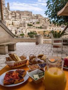 a table with a plate of food and a glass of orange juice at La Corte Dei Pastori Luxury in Matera