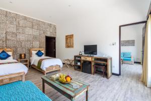 ギリ島にあるKura Kura Resort Gili Menoのベッド2台とテレビが備わるホテルルームです。