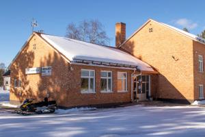 a brick building with a snowmobile parked in front of it at Dalasjö vandrarhem in Vilhelmina