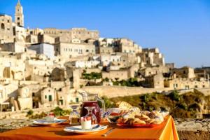 - une table avec de la nourriture et une vue sur la ville dans l'établissement La Corte Dei Pastori Luxury, à Matera