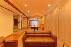 a living room with a couch and a table at Ryokan -Suikoen- by Tranova in Yugawara