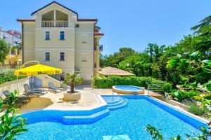 a swimming pool in front of a house at Nur 140 Meter zum Strand mit Pool in Crikvenica