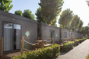 马格拉hu Venezia Camping in Town的一座拥有一排木桌和长椅的建筑