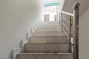 una scala in una casa con pareti bianche e gradini bianchi di OYO Siddhi Vinayak Guest House a Gwalior