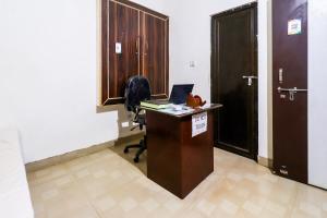 an office with a desk with a laptop and a door at OYO Siddhi Vinayak Guest House in Gwalior