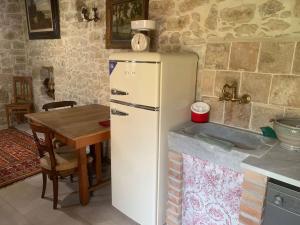 a white refrigerator in a kitchen with a table at Casa tipica sarda 
