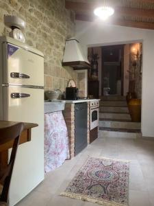 a kitchen with a white refrigerator and a stove at Casa tipica sarda in Gonnosnò