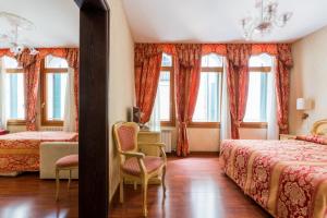 a hotel room with two beds and windows at Locanda Al Leon in Venice