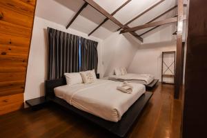 - une chambre avec 2 lits et une fenêtre dans l'établissement 60s Town, à Hua Hin