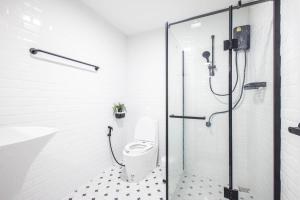 a bathroom with a shower and a toilet and a sink at 60s Town in Hua Hin