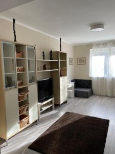 salon z telewizorem i kanapą w obiekcie SunCity Apartman w Segedynie