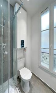 uma casa de banho com um WC e uma cabina de duche em vidro. em Champs Elysées area - Deluxe Family Apartments em Paris