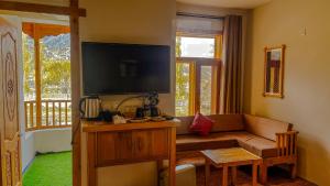 a living room with a couch and a flat screen tv at Villa Darya - Truly Hunza in Gulmit
