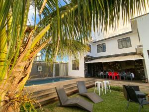 una casa con piscina, sillas y una palmera en Mungur villa, en Flic en Flac