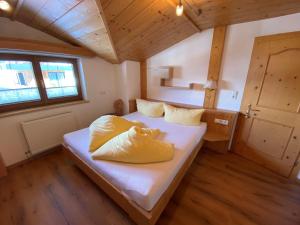 Un dormitorio con una cama con almohadas amarillas. en Apartment Seespitz, en Längenfeld