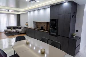 a kitchen and living room with a white table and chairs at A-Dent luxury apartments & Dental Clinic in Gotse Delchev