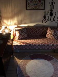 a living room with a couch with pillows and a rug at M&M STONE-Village House-Family-Vintage in Líndos