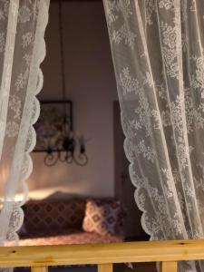 a window with a curtain with a couch in a room at M&M STONE-Village House-Family-Vintage in Líndos