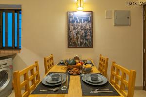 a dining room table with a bowl of fruit on it at EKO STAY - Woodlock Apartment in Candolim +18 photos
