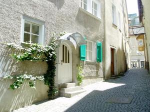 een gebouw met een witte deur en bloemen op een straat bij Ferienwohnung Altes Haus 4 in Lindau