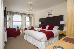 a hotel room with a large bed and a desk at Ellan Vannin Hotel in Douglas