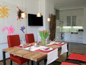uma sala de jantar com uma mesa e cadeiras vermelhas em Ferienwohnung Belle Etage em Lindau