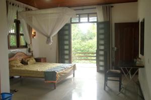 a bedroom with a bed in a room with a window at The Breeze Pinnawala in Pinnawala