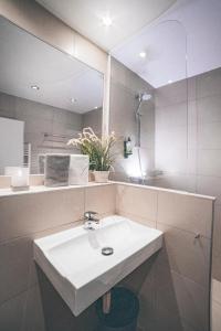 a bathroom with a white sink and a mirror at Gartenstadt Hotel in Ludwigshafen am Rhein