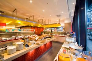 a restaurant with a buffet line with food at Novotel Aachen City in Aachen