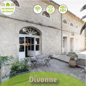 a building with a patio with a table in front of it at Divonne - Loft cosy avec jardin partagé in Arles